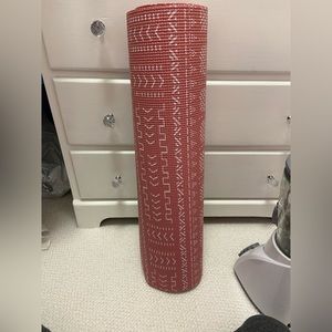 Pink yoga mat with white markings.